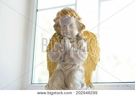 Statue of an angel in a church on a windowsill