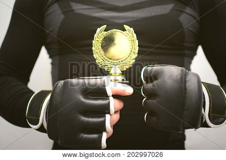 Boxing king fighter champion best of the best concept. Fighting competition winner man holds in hand his golden award close up.