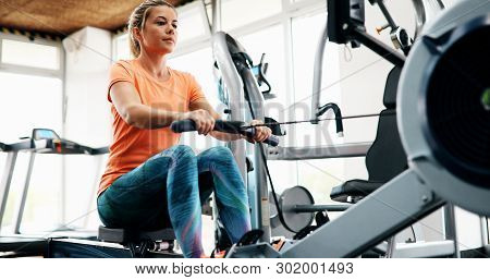 Woman Pulling On Row Machine In Fitness