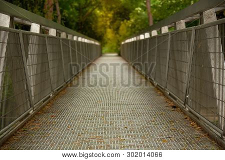 A Meatal Footpath Bridge In The Park On Rainy Day