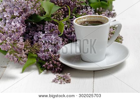 Little Delicate Elegant Bouquet Of Spring Flowers And A Teacup On White Wooden Table, Morning Breakf