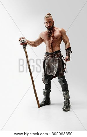 Serious Long Hair And Muscular Male Model In Leather Vikings Costume With The Big Mace Cosplaying Is