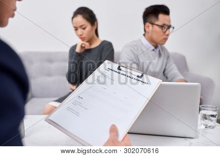 Young Angry Couple Of Cheated Investors Holding Papers Arguing With Male Real Estate Agent, Defraude