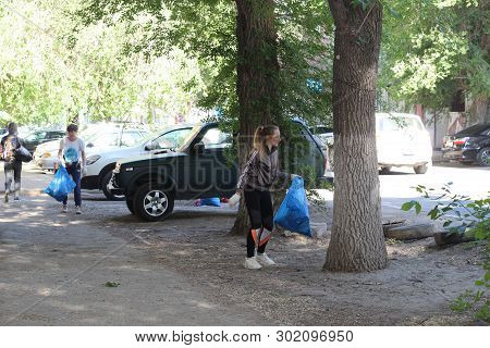 Plogging. Girls Run And Collect Garbage In Bags On The Streets Saratov, Russia, 10 June 2018