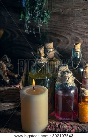 A Witchery Stuff: Multiple Tincture Bottles, Bunches Of Dry Healthy Herbs, Stack Of Ancient Ritual T