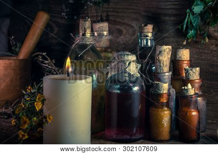 A Witchery Stuff: Multiple Tincture Bottles, Bunches Of Dry Healthy Herbs, Stack Of Ancient Ritual T