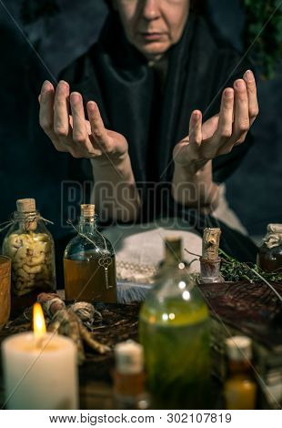 Dark Witch At Work: Black Magic Woman Makes The Witchery By Mixing Herbs, Casting The Spells, Runnin