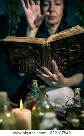 Dark Witch At Work: Black Magic Woman Makes The Witchery By Mixing Herbs, Casting The Spells, Runnin