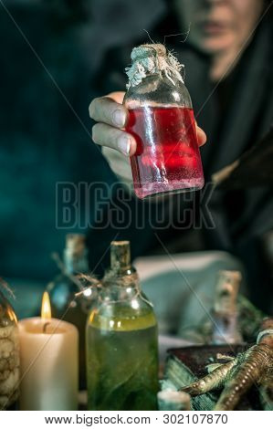 Dark Witch At Work: Black Magic Woman Makes The Witchery By Mixing Herbs, Casting The Spells, Runnin