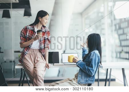 Two Young Casual Business People On The Break. Happy Colleagues Takling With A Cup Of Coffee.