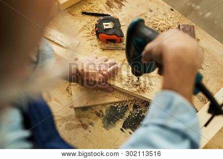 Above View Of Unrecognizable Carpenter Drilling Wood While Working In Joinery, Copy Space