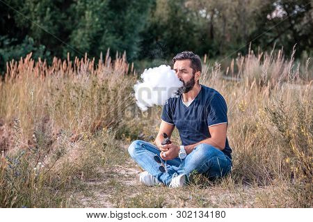 Modern Vaper Exhales Cloud Of Smoke. Stylish Man.