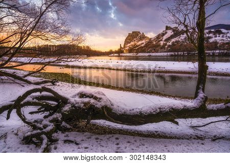 Snow Covered Devin Castle Ruins Above The Danube River In Bratislava, Slovakia At Sunrise