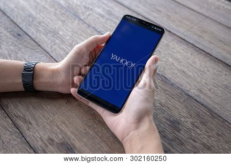 Chiang Mai  Thailand - May 11 2019 : Hands Hoding Oneplus 6 With Yahoo Screen, Coffee And Keyboard O