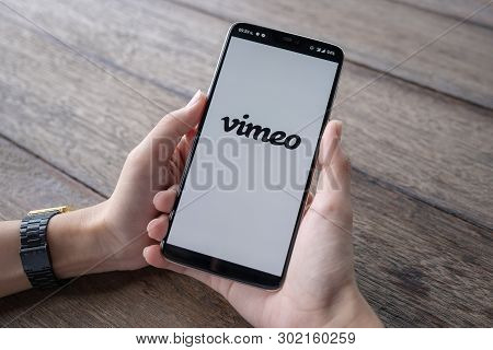 Chiang Mai,  Thailand - May 11 2019 : Hands Hoding Oneplus 6 With Vimeo Screen, Coffee And Keyboard 