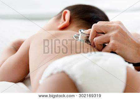 Pediatrics Doctor Examining Heartbeat And Lungs Of Little Baby Boy With Instruments Stethoscope, Hea