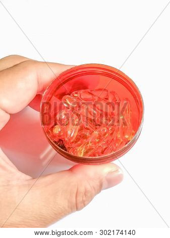 Fishoil Capsule In Jar On Hand On White Background