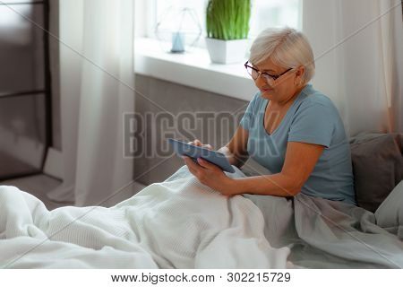 Nice-appealing Lady Watching A Movie While Lying In The Bed