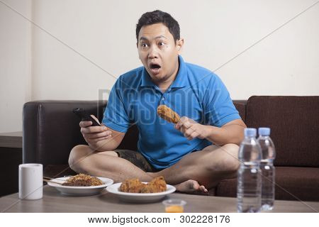 Asian Man Watching Soccer On Tv