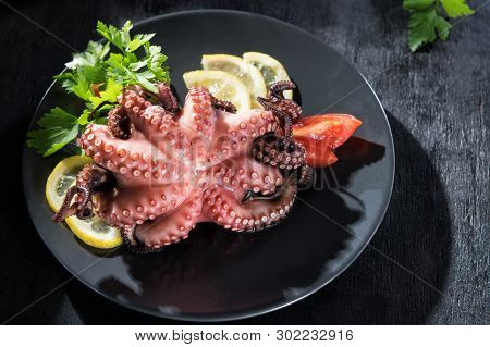 Stuffed Octopus In White Wine With Lemon And Tomatoes. Octopus Dishes Of Salento, Puglia, Italy