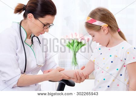 Woman medic making important Mantoux test to pretty child