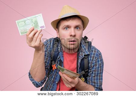 Tourist In Hat Holds Euro Bank Note Checking It