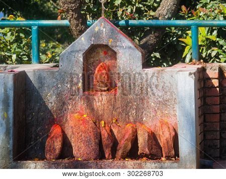 Shrine covered in vermillion to worship Goddess Kali. Red pigment powder on stone, part of Kali Shrine on the mountain in Dhulikhel, Nepal