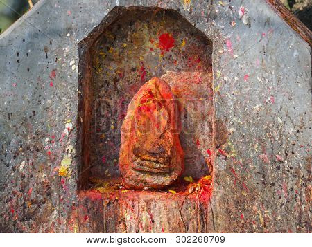 Shrine covered in vermillion to worship Goddess Kali. Red pigment powder on stone, part of Kali Shrine on the mountain in Dhulikhe, Nepal