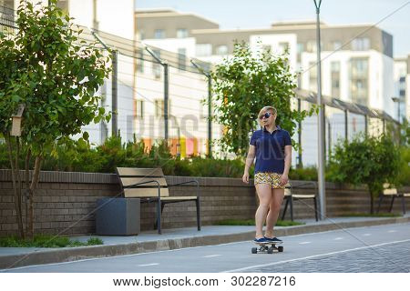 Sporty Stylish Plussize Girl In Sunglasses Rides A Longboard Along The Tracksporty A Path Past Trees