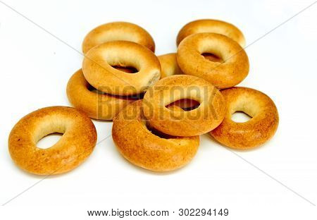 Stack Of A Dozen Golden Brown Bagels In A Variety Of Flavors. Everything Bagels Isolated On White Ba