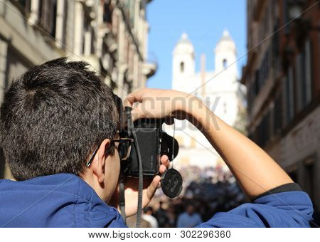 Young Photographer With Digital Camera In Via Dei Condotti In Rome Italy And The Church Of The Trini
