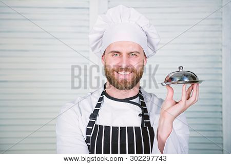 Chefs Dish. Man Cook Hat And Apron Hold Meal Covered With Lid. Delicious Meal Presentation. Haute Cu