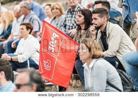 Caceres, Extremadura, Spain - May 20, 2019: A Member Of The Party With A Flag Attends The Meeting Of
