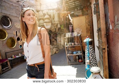Tourist girl shopping in Moroccan souk of Marrakech