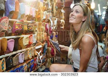 Tourist girl shopping in Moroccan souk of Marrakech