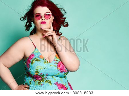 Choosy Plus-size Lady Overweight Woman In Modern Sunglasses And Colorful Sundress With Her Hand At H