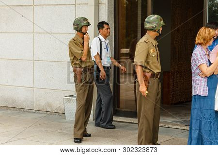 Panmunjom, North Korea - July 30, 2014: North Korean Soldiers Guard Tourists On The Border With Sout