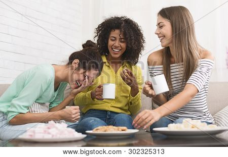 Diverse Roommates Drinking Coffee, Eating Cookies And Laughing At Home