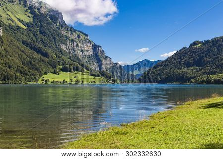 Mountain Lake Klöntalersee On Background Of Majestic Mountains At Bright Cloudy Sky Day. Glarus Cant