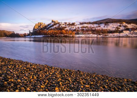 Snow Covered Devin Castle Ruins Above The Danube River In Bratislava, Slovakia At Sunrise