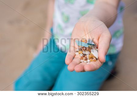 Little Girl Holding Small Tiny Harmful Plastic Beads Collected On The Beach In Zante, Zakynthos, Gre