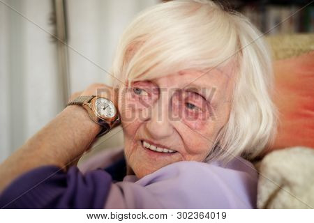 Blind Old Woman Listens To The Time On Her Speaking Wrist Watch.