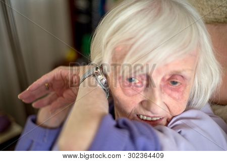 Elderly Lady With Macular Degeneration Listens To Her Speaking Wrist Watch,england,u.k.