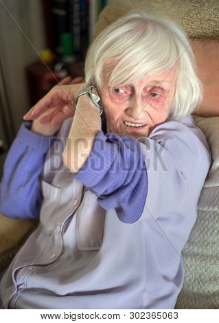 Elderly Woman With Visual Impairement Listening To Speaking Wrist Watch,england,u.k.