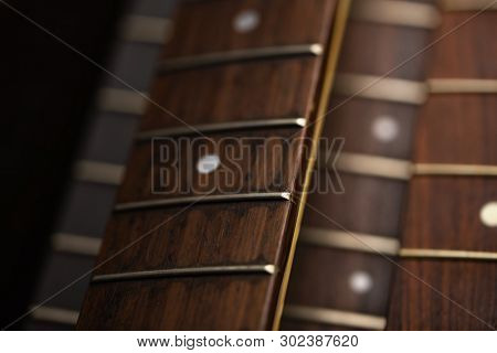 Many guitar necks aligned. Rosewood and ebony finger board electric guitar necks made from maple.