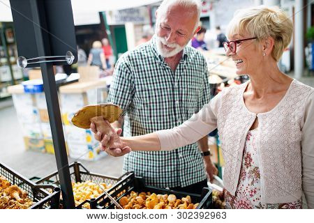 Shopping, Food, Sale, Consumerism And People Concept - Happy Senior Couple Buying Fresh Food