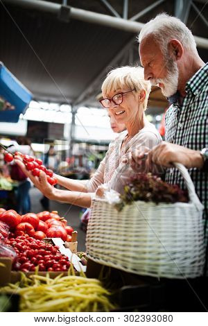 Shopping, Food, Sale, Consumerism And People Concept - Happy Senior Couple Buying Fresh Food