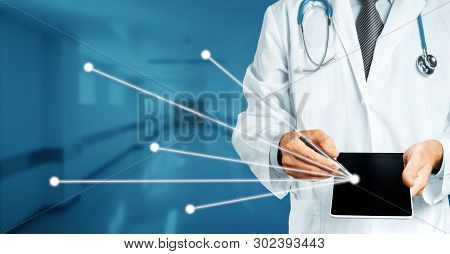 Doctor In White Coat With Stethoscope Holds In His Hand Digital Tablet With History Of The Disease (