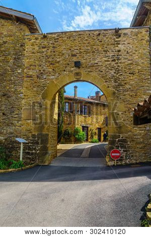 Oingt, France - May 07, 2019: The Old Gate Of The Medieval Village Oingt, With A Visitor, In Beaujol