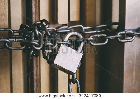 High Security Locked Door By Brass Padlock And Big Chain. Safety And Security Concept.